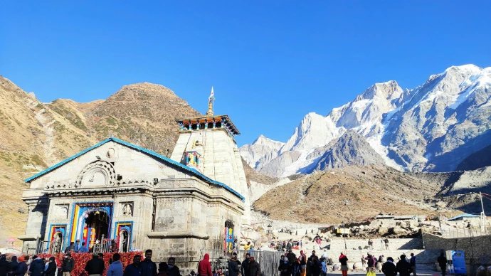 Temple with snow-capped mountains and pilgrims